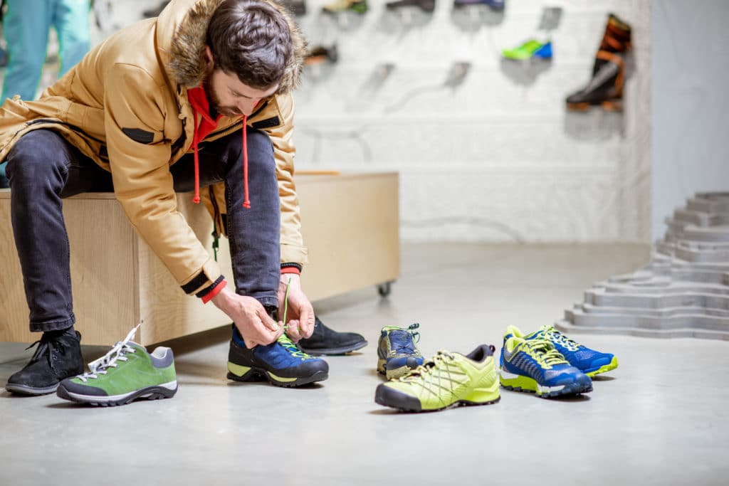 Man trying shoes for hiking in the shop