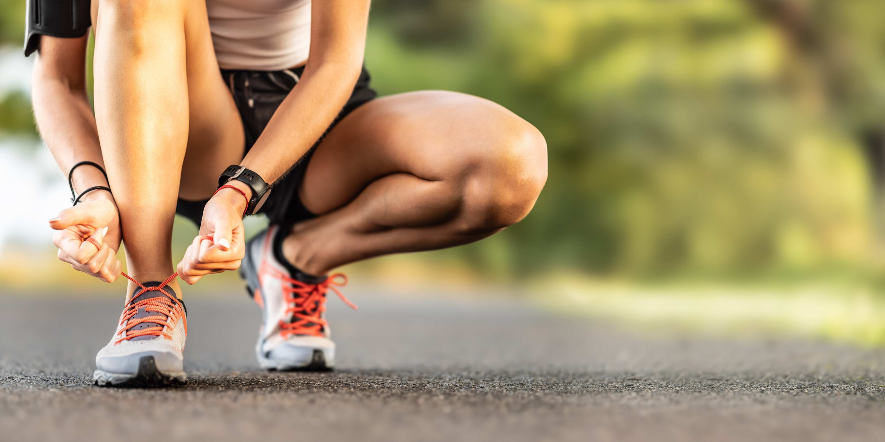 Woman runner tying shoelace ready to run on road